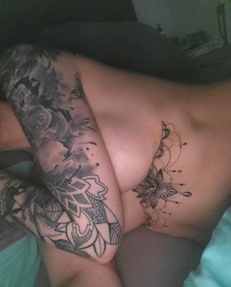 Cute tattooed amateur teases hotly with her covered big tits in her bedroom