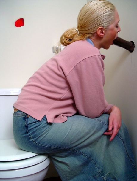 Blonde girl Jamie sits on the toilet and blows a black gloryhole dong
