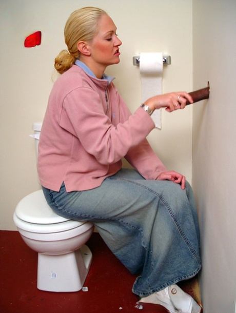 Blonde girl Jamie sits on the toilet and blows a black gloryhole dong