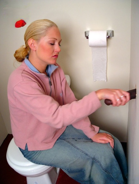 Blonde girl Jamie sits on the toilet and blows a black gloryhole dong