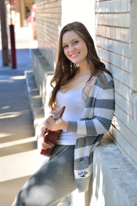 Bosomy babe Summer exposes her big ass while playing a small guitar in public