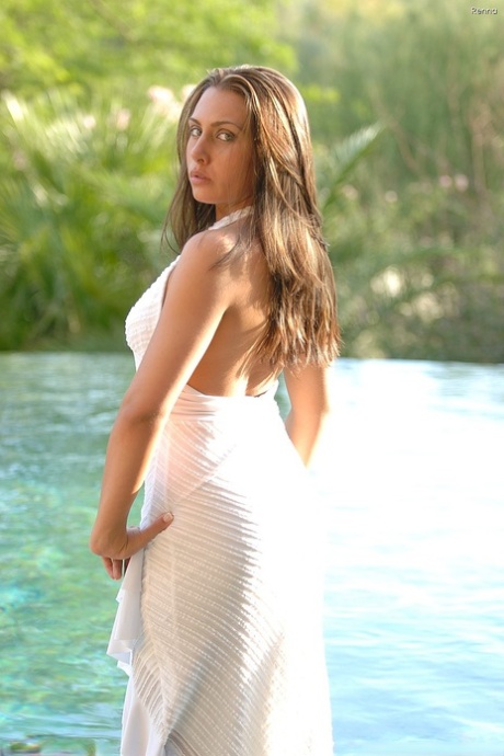 Tanned amateur babe Renna poses in the pool in her tight white dress